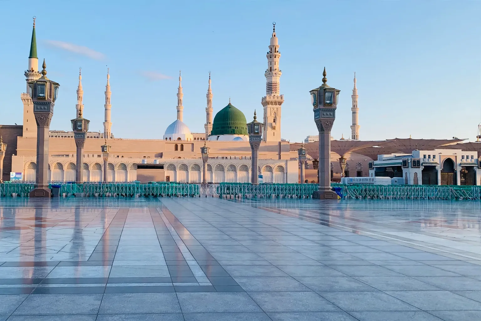 Kubah hijau dan menara Masjid an-Nabawi terlihat dari seberang plaza pada pagi hari